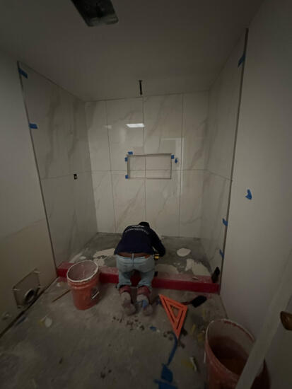 Photo of a restoration technician setting tiles