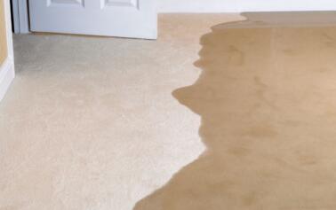 flooding water spreads quickly into a living room and causing water damage.